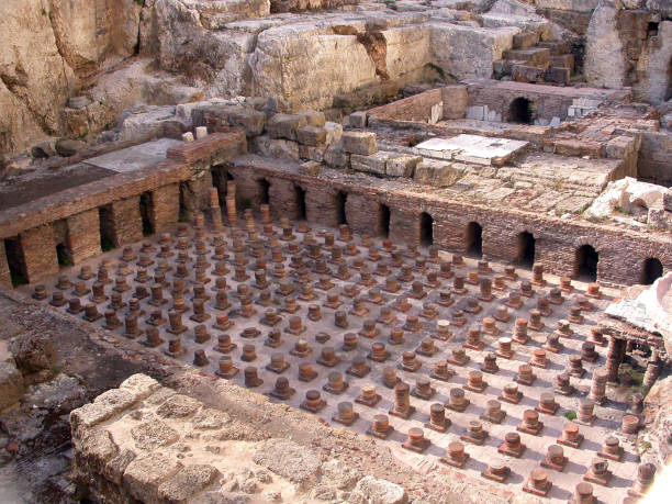 Timeless Echoes: Roman Baths of Berytus Resurrected Nestled within the historic heart of ancient Berytus, these meticulously preserved Roman Baths Ruins reveal terracotta pillars and arched fire vaults, beckoning visitors to step into an ancient gathering space, where marble floors concealed cherished stories and resonated with the jubilance of bygone times. roman baths stock pictures, royalty-free photos & images