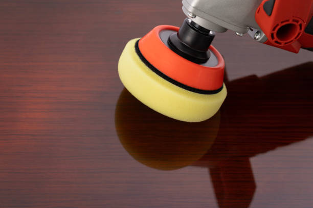 istock Polishing machine with yellow polisch pad on painted wooden surface 1694184647