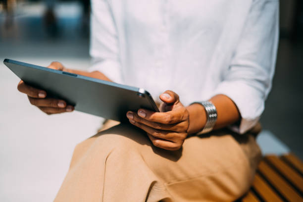 An Unrecognizable Beautiful Businesswoman Watching Something On Her Tablet While Relaxing Outdoors