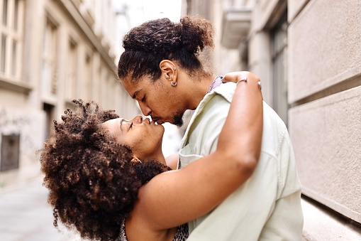 Multiracial couple in love kissing on the street