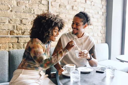 Multiracial man and woman drinking coffee at the cafe
