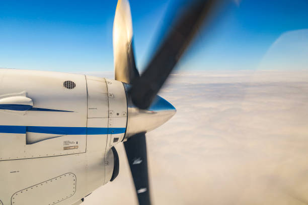 Airplane propeller spinning in small aircraft flying above the clouds.