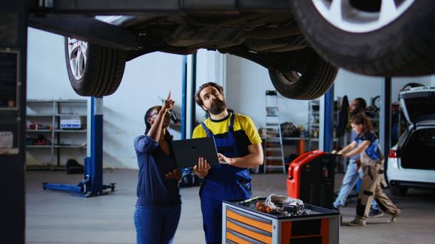 istock Serviceman looks online for car parts 1694225914