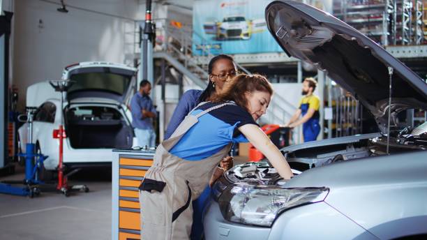 istock Technician in garage cleans customers car 1694238433