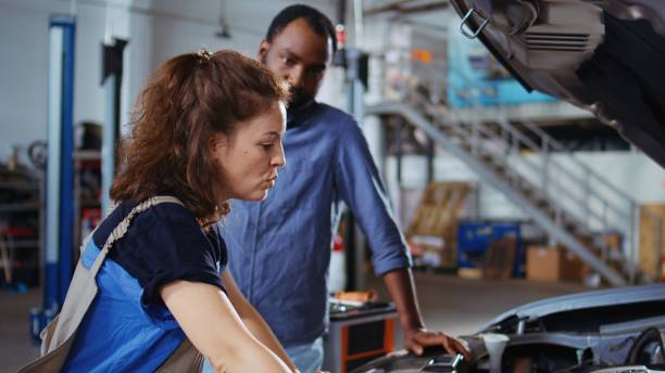 istock Engineer in garage cleans customers car 1694238970