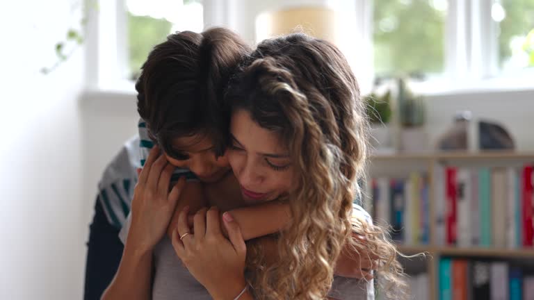Affectionate mother and son hugging and looking very happy at home