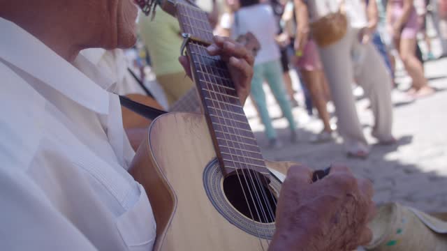 Senior man playing the guitar outdoors