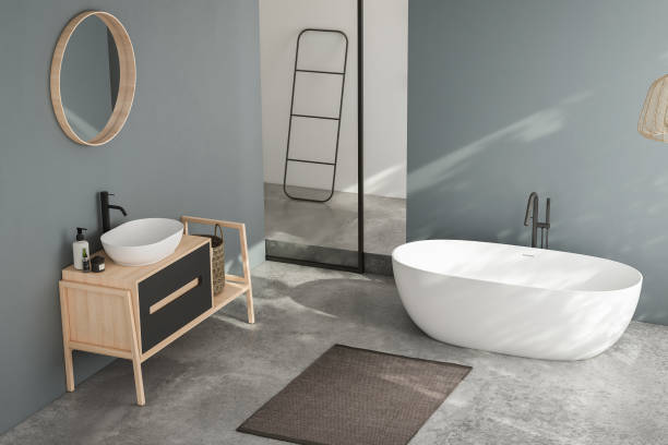 istock Modern minimalist bathroom interior, modern bathroom cabinet, white sink, wooden vanity, interior plants, bathroom accessories, bathtub and shower, white and blue walls, concrete floor. 1694251282