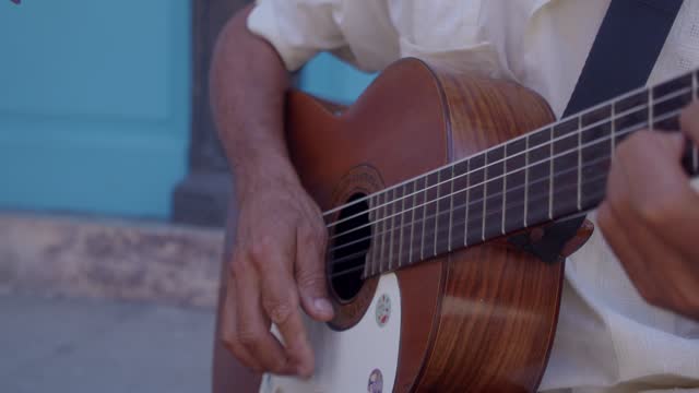 Close-up of cuban playing guitar outdoors