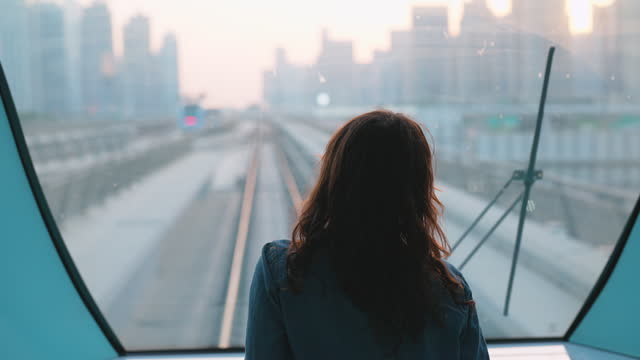 Woman traveling in Dubai metro at sunset