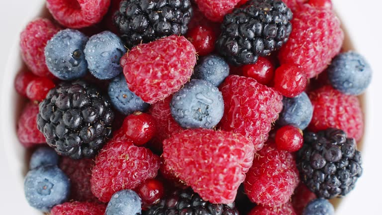 Healthy fruit berries.Pattern Fresh fruit snack. Vitamin K. Summer concept Fresh raspberries, blackberries, blueberries, red currants rotate in white bowl on an isolated white background top view