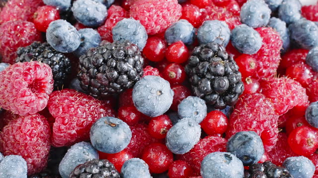 Pattern Fresh raspberries, blackberries, blueberries, red currants rotate top view close up. Healthy fruit berries.Pattern Fresh fruit snack. Vitamin K. Summer concept
