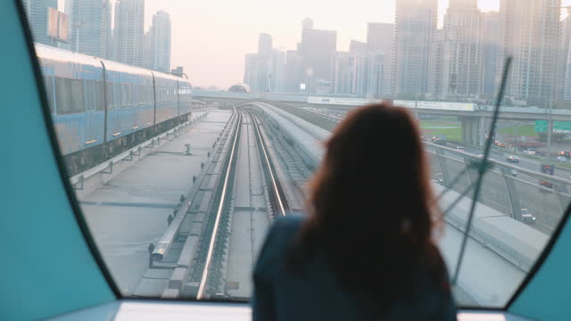 Woman traveling in Dubai metro at sunset