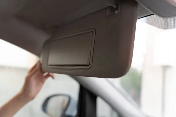 Photo of Man Holding Sun Visor In Car