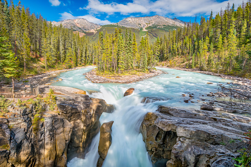 A breathtaking view of amazing Sunwapta Falls Waterfall in Canada with silk effect water and colorful trees