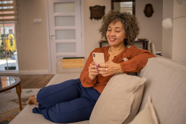 istock Happy mature woman using phone 1694498780