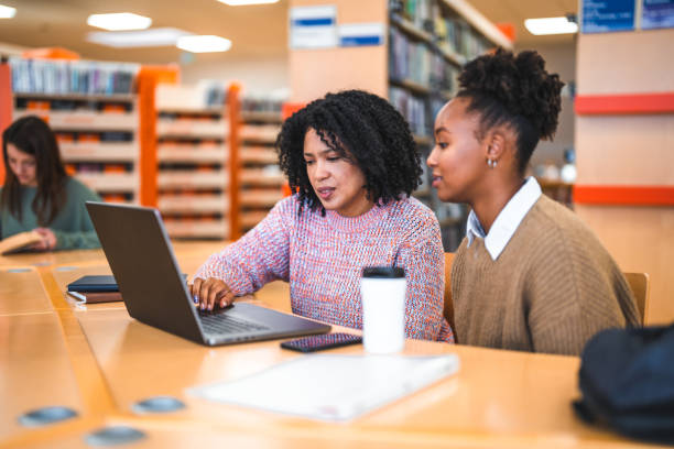 istock Hispanic Females Studying In A Library Using Laptop 1694509106
