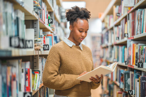 istock Hispanic Female In 20s Flipping Through A Book In A Library 1694509336