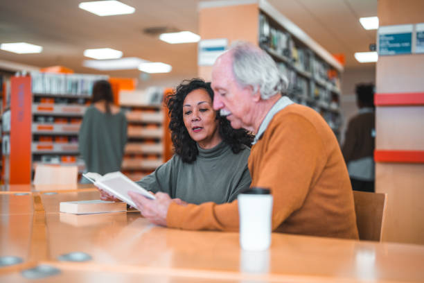 istock Book Club Members Reading Together In A Library 1694509343