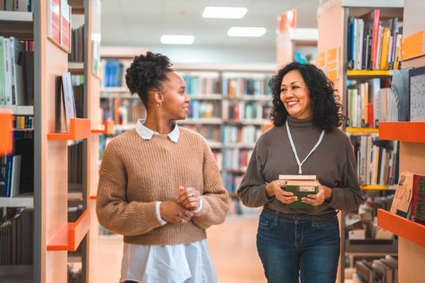 istock Hispanic Females Walking Through The Library 1694509379