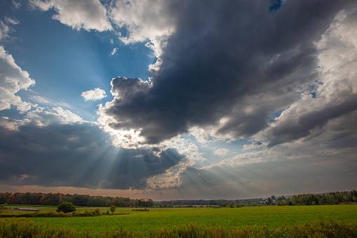 Wisconsin farmland with sunrays coming out of the clouds in September, horizontal