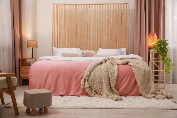 istock Stylish bedroom with comfortable bed, bedside table and ottoman. Interior design 1694552909