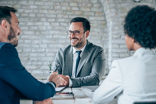 Shot of group of business persons in business meeting. Three entrepreneurs on meeting in board room. Corporate business team on meeting in modern office. Male manager discussing new project with his colleagues. Company owner on a meeting with two of his employees in his office.