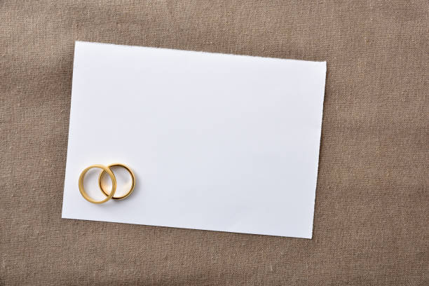 istock Blank wedding card with rings background on brown cloth 1694570912