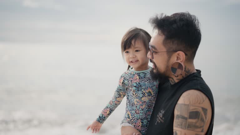 kind father and cute little daughter spend time at the seaside enjoying the beautiful sea view.