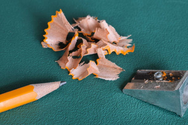istock Yellow pencil and sharpener with shavings on green background 1694588972