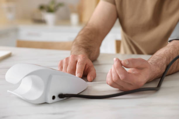 istock Man measuring blood pressure at table indoors, closeup 1694593814