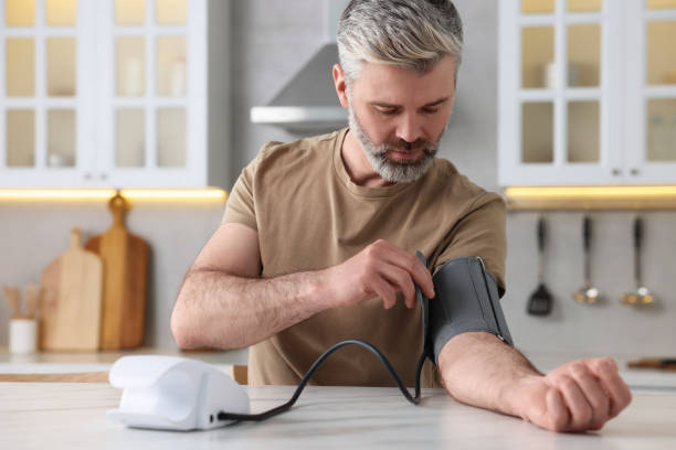 istock Man measuring blood pressure at table indoors 1694595415