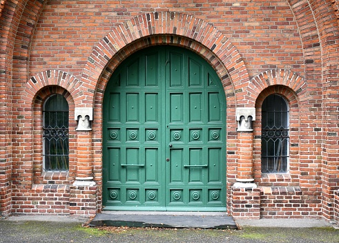 On the side of a building an unusual looking window and brick design