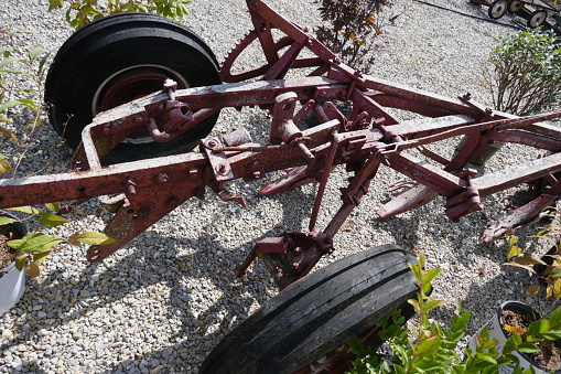 Old metal farming plow with rubber tires