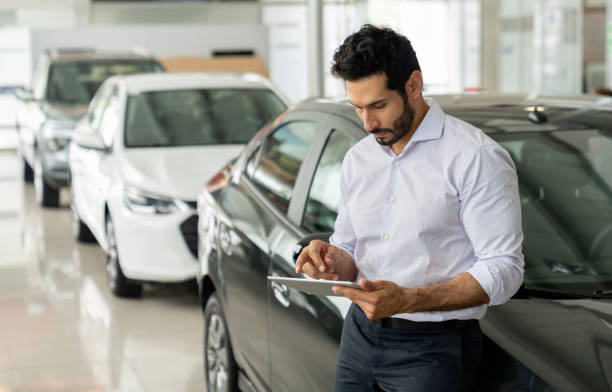 istock Car salesperson working at the dealership using a digital tablet 1694629241