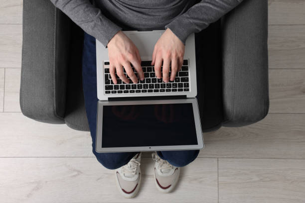 istock Man working with laptop in armchair, top view 1694656688