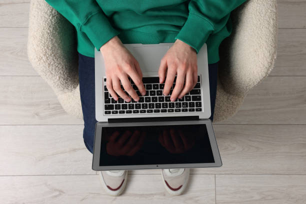 istock Man working with laptop in armchair, top view 1694656691