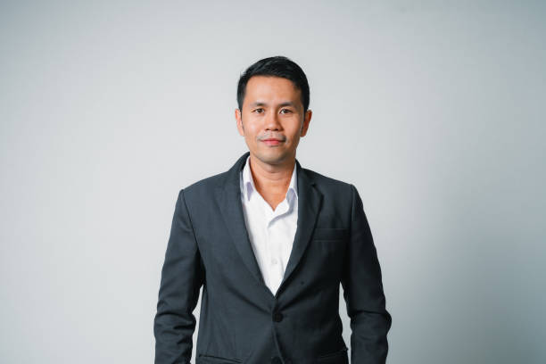 istock Asian businessman in suit with looking at camera standing studio isolated on gray background, young asian business man is manager or executive smiling and having confident is positive with success. 1694671206