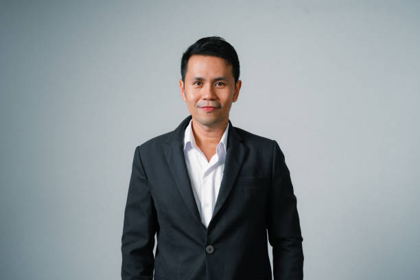 istock Asian businessman in suit with looking at camera standing studio isolated on gray background, young asian business man is manager or executive smiling and having confident is positive with success. 1694671741