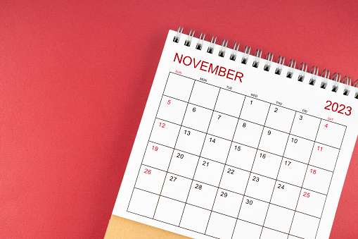 November 2023 desk calendar on red color background.