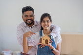 Indian couple is holding for a model home to choose a new home. relocation concept