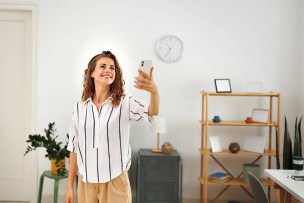 istock Young beautiful woman controlling security system with mobile app 1694749517