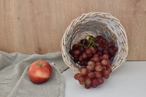 Red grapes in wicker basket on the table