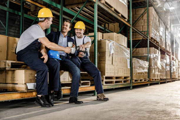 istock Happy manual workers and their inspector having coffee break in warehouse. 1694813194