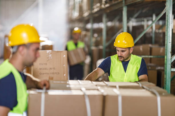istock Young warehouse worker working cardboard boxes in industrial building. 1694814209