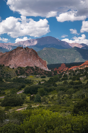 Pike's Peak towers in the background over the some of the rock formations in Garden of the Gods in Colorado Springs, Colorado, during the summertime.
