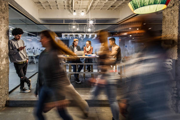 istock Young creative people working in the office among people in blurred motion. 1694814989