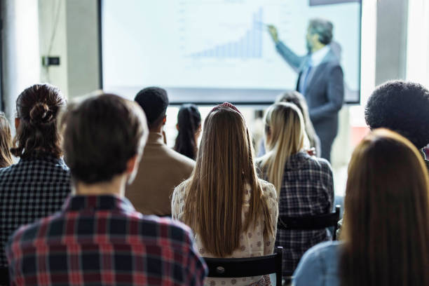 istock Back view of creative people on education event in the office. 1694815024