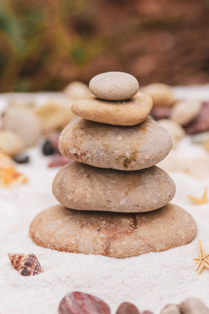 istock Balancing rocks spiritual ritual on the white beach sand. 1694833598