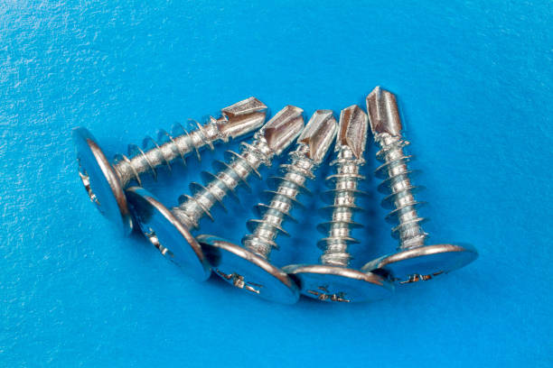 파란색 배경에 금속 나사입니다. - screw threaded construction equipment blue 뉴스 사진 이미지